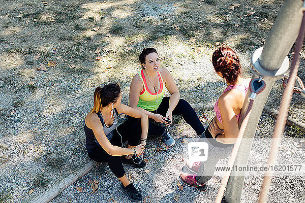 Friends taking break from exercise in park