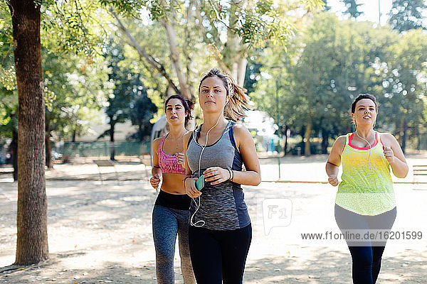 Drei Freunde joggen im Park