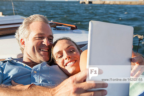 Ehepaar auf Yacht mit digitalem Tablet