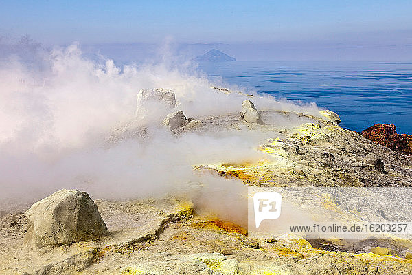 Steam from hot spring on rocky hill