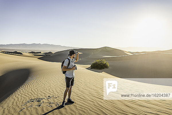 Mann mit Fernglas  Mesquite Flat Sand Dunes  Death Valley National Park  Furnace Creek  Kalifornien  USA