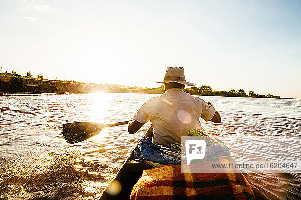 Rear view of man rowing boat onTsiribihina River  Madagascar  Africa