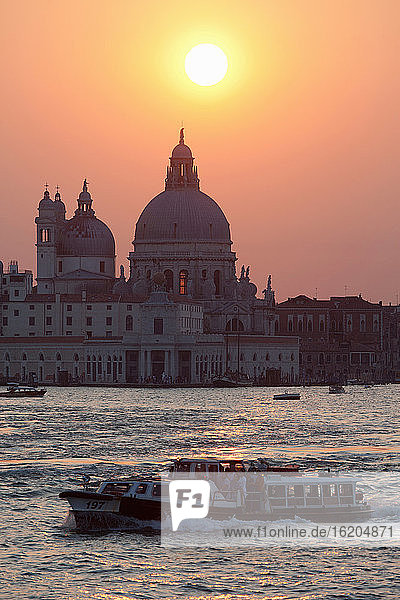 Vaporetto auf dem Canal Grande bei Sonnenuntergang  Basilica di Santa Maria della Salute im Hintergrund  Venedig  Italien