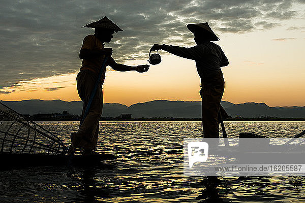 Two fishermen drinking tea at dusk  Inle lake  Shan State  Myanmar