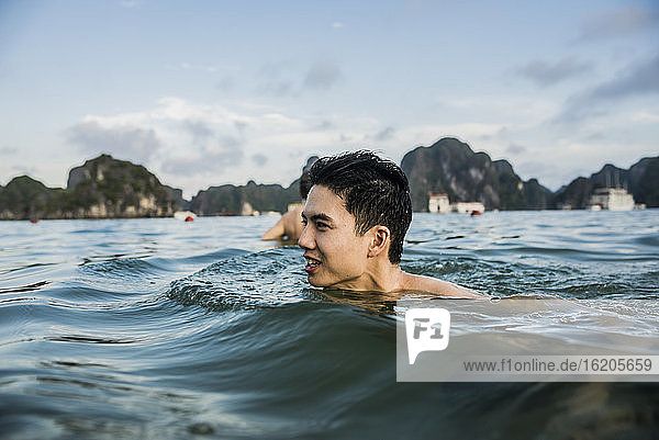 Mann schwimmt in den Gewässern der Ha Long Bay  Vietnam