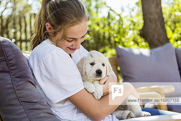 Teenage girl holding a English golden retriever puppy
