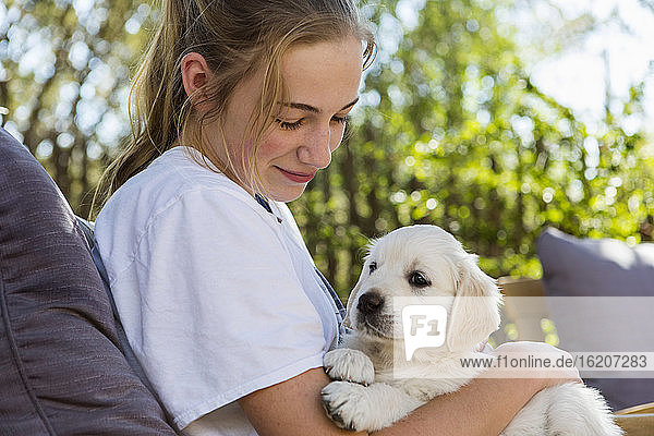 Teenage girl holding a English golden retriever puppy