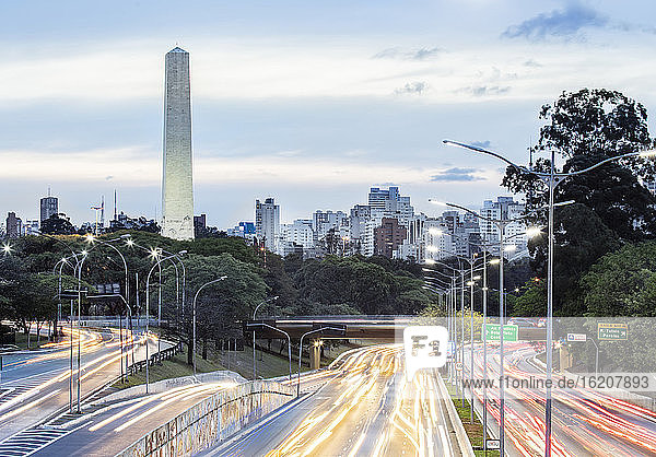 Ampelschleifen zur Hauptverkehrszeit auf der Avenida 23 de Maio  der Skyline und dem Obelisken der Helden im Ibirapuera-Park  Sao Paulo  Brasilien  Südamerika