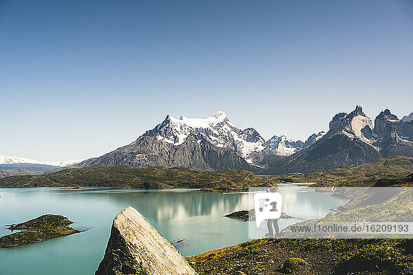 Man looking at Lake Pehoe through binocular in Torres Del Paine National Park  Chile Patagonia  South America