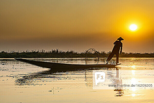 Myanmar  Shan state  Silhouette of traditional Intha fisherman on Inle lake at sunset