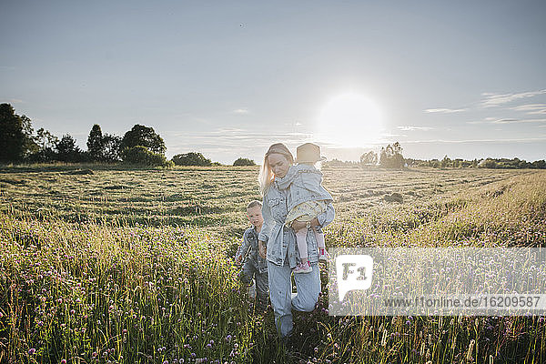 Lächelnde Mutter mit zwei Kindern auf einem Feld