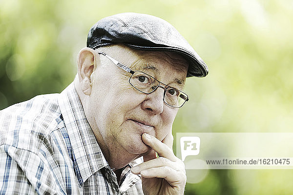 Germany  North Rhine Westphalia  Cologne  Senior man with cap and glasses in park  close up