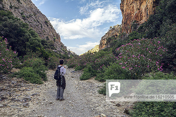 Mann mit Rucksack auf einem Berg in Griechenland stehend