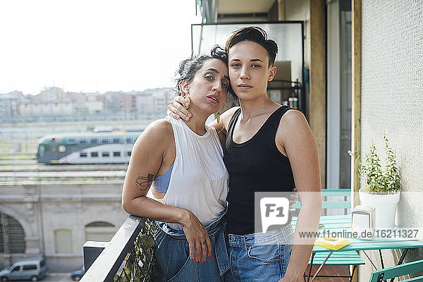 Lesbisches Paar auf dem Balkon stehend mit Arm um Arm