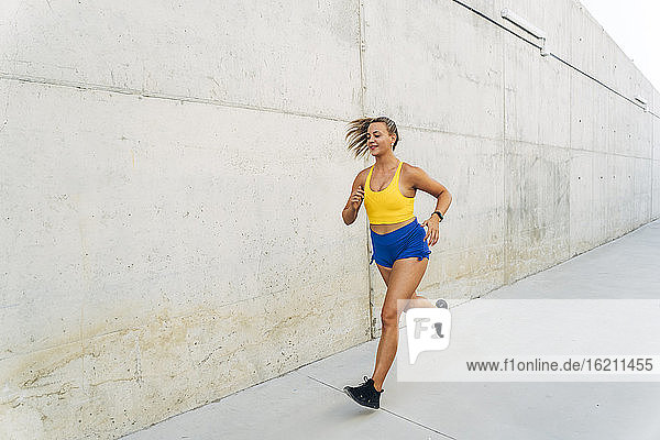 Female jogger in front of wall