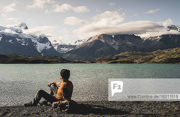 Man sitting and admiring view of Lake Pehoe in Torres Del Paine National Park  Chile Patagonia  South America