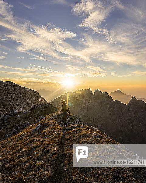 Wanderin auf dem Weg zum Aussichtspunkt bei Sonnenuntergang  Hochplatte  Bayern  Deutschland