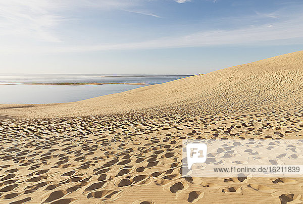 Dune of Pilat by Atlantic ocean against sky on sunny day  Dune of Pilat  Nouvelle-Aquitaine  France
