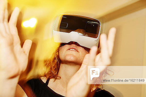 Nahaufnahme einer Frau  die zu Hause durch einen Virtual-Reality-Simulator schaut