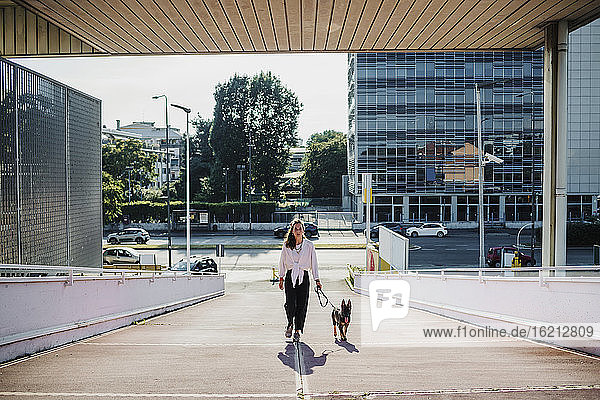 Woman walking with dog on elevated walkway