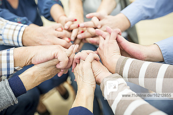 Nahaufnahme von Senioren  die sich die Hände reichen  als Symbol der Solidarität