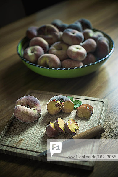 Schale mit Pfirsichen auf Holztisch