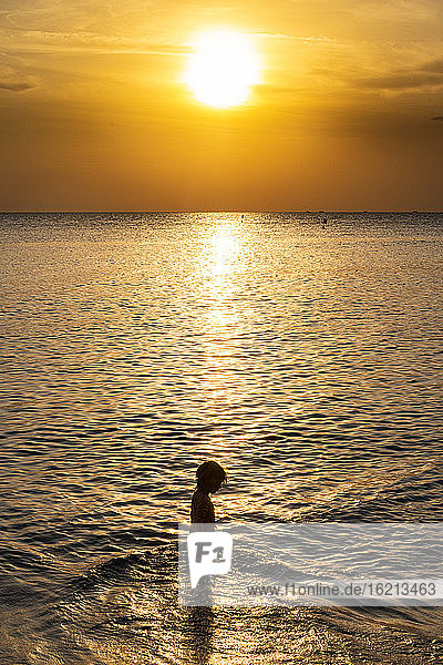 Vietnam  Phu Quoc island  Ong Lang beach  Silhouette of girl in sea at sunset