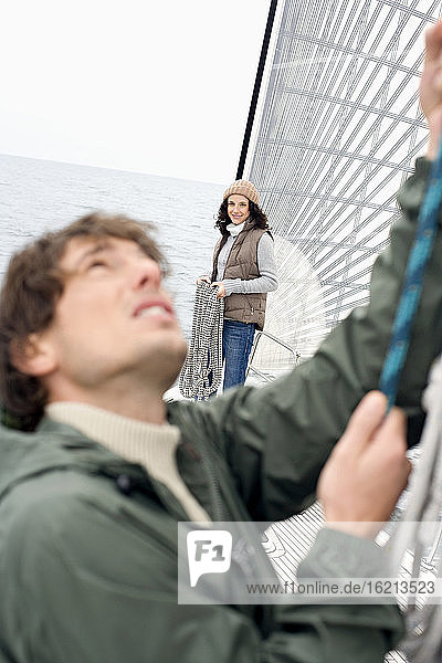 Germany  Baltic Sea  Lübecker Bucht  Young couple on sailing boat