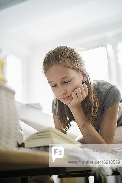 Mädchen liest ein Buch zu Hause