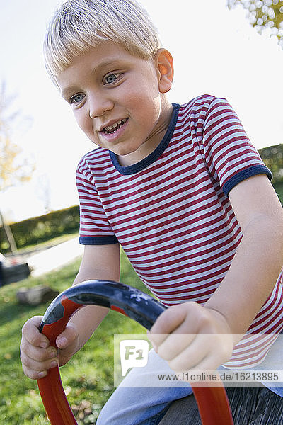 Kleiner Junge (4-5) spielt auf dem Spielplatz