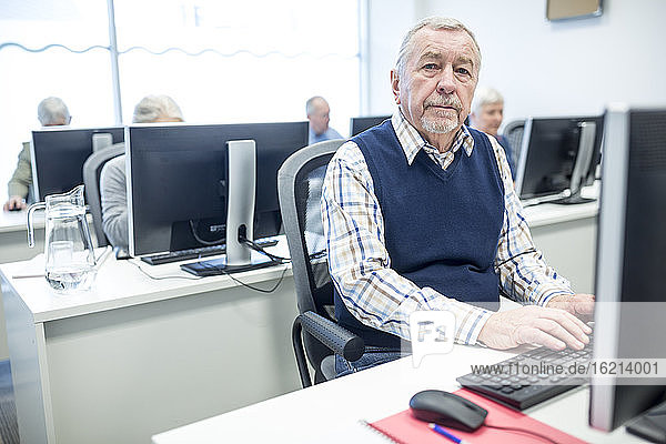 Senior man attending computer course