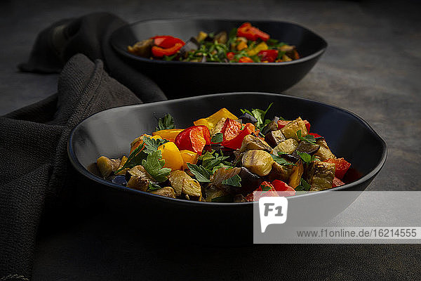 Zwei Schalen mit veganem Salat mit Auberginen  Paprika und Petersilie