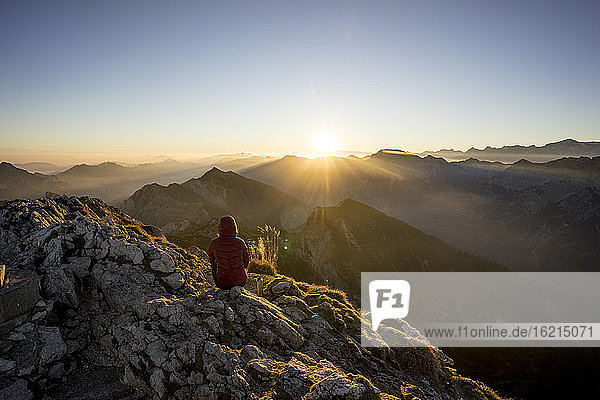 Female hiker sitting on viewpoint during sunset  Hochplatte  Bavaria  Germany
