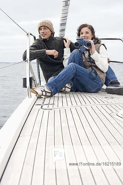 Germany  Baltic Sea  Lübecker Bucht  Young couple on boat  woman holding binoculars