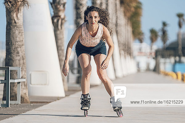Young woman inline skating on promenade at the coast