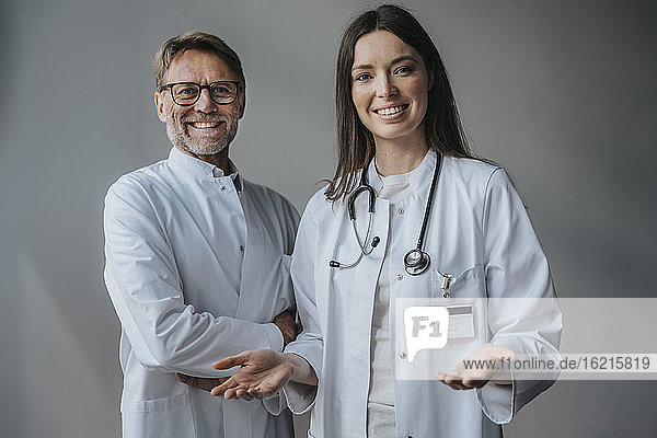 Lächelnde Ärzte  die in einem Krankenhaus an der Wand stehen