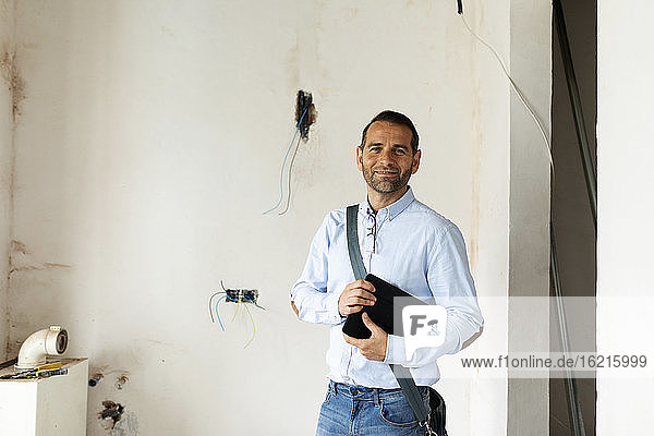 Portrait of a confident architect in a house under construction