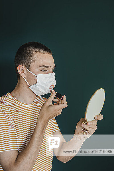 Junger Mann beim Schminken einer Schutzmaske