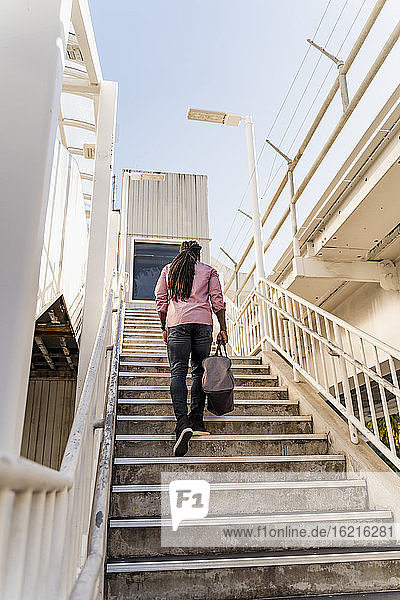 Junger Afroamerikaner mit Tasche auf einer Treppe in Miami  Florida  USA