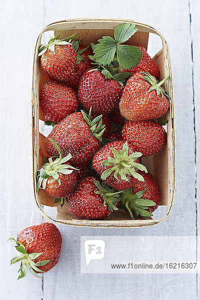 Kiste mit Erdbeeren auf Holztisch  Nahaufnahme