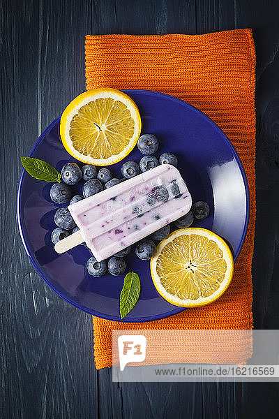 Blaubeer-Joghurt-Bonbon mit Orangenscheiben auf einem Teller  Nahaufnahme