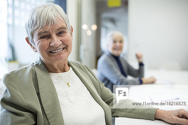 Glückliche Seniorin  die an einem Kurs für Seniorenbildung teilnimmt