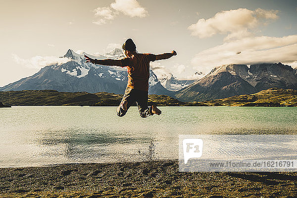 Man jumping and enjoying at lake Pehoe in Torres Del Paine National Park Patagonia  South America