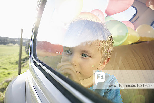 Deutschland  Nordrhein-Westfalen  Köln  Junge im Auto schaut durch Fenster  Nahaufnahme