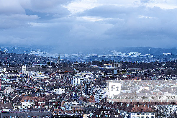 Schweiz  Zürich  Gewitterwolken über der Stadt mit schneebedeckten Bergen im Hintergrund  Luftaufnahme
