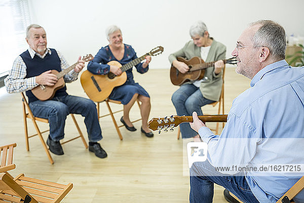 Senioren im Altersheim besuchen Gitarrenkurs  machen Musik