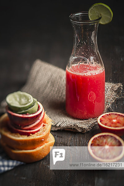 Flasche mit Saft und Blutorangen auf dem Tisch  Nahaufnahme