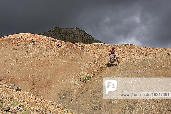 Island  Mann beim Mountainbiking in hügeliger Landschaft