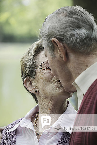 Deutschland  Köln  Älteres Paar küsst sich im Park