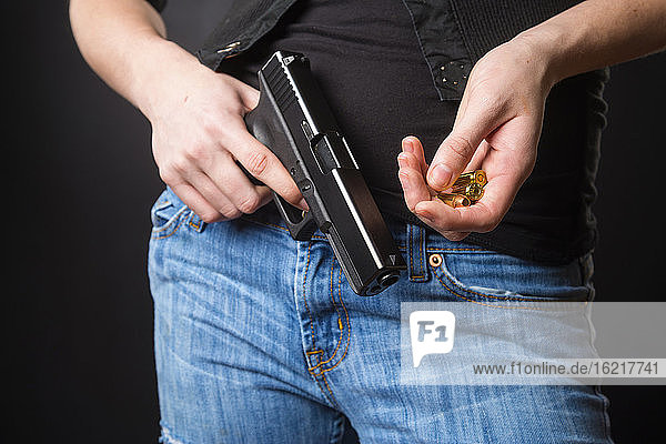Junge Frau lädt Magazin einer Handfeuerwaffe auf